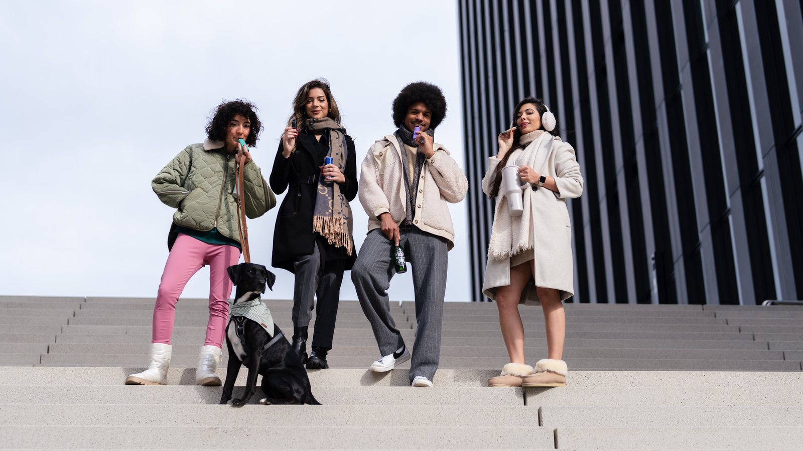 Group lifestyle photography — four people on outdoor steps with a dog, urban architecture, product shoot by Pixer